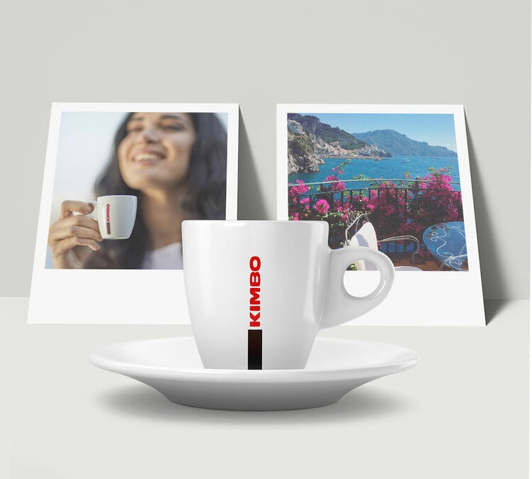 Cup of Kimbo Aroma Gold coffee served in a warm, authentic Italian atmosphere with photos in the background