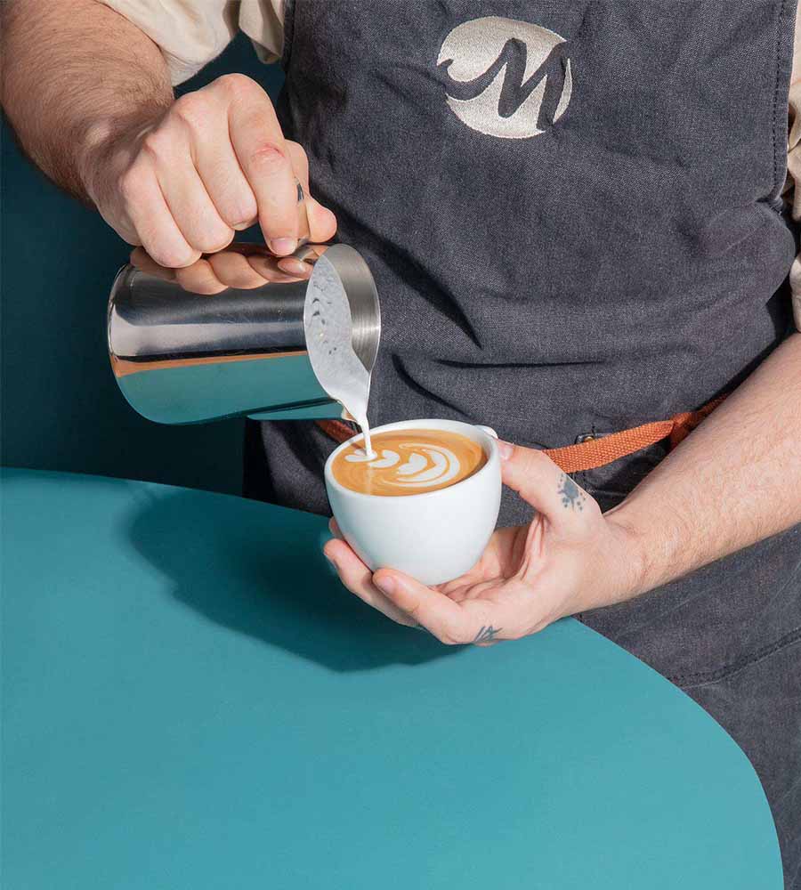 personne realisant un cappuccino